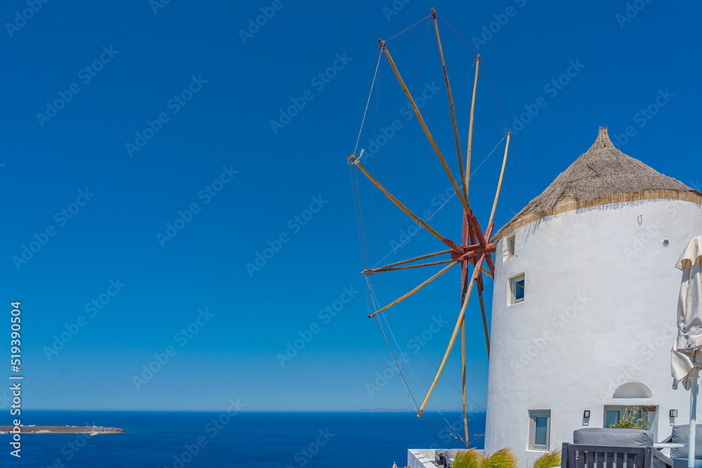 Φωτογραφία View of a mill in Oia on Santorini island, Greece, background the blue sea