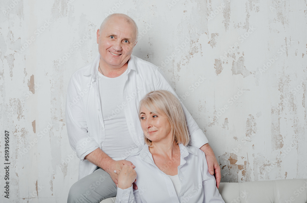a man and his wife in white shirts on the couch a man and his wife in white shirts on the couch