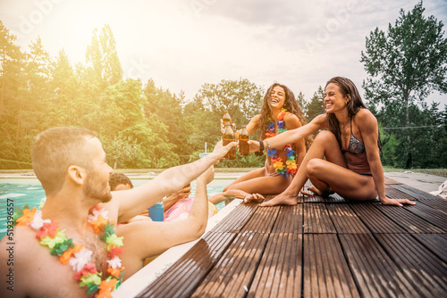 Canvas Print Group of friends at hotel outdoor pool during summer party toast with beer and c
