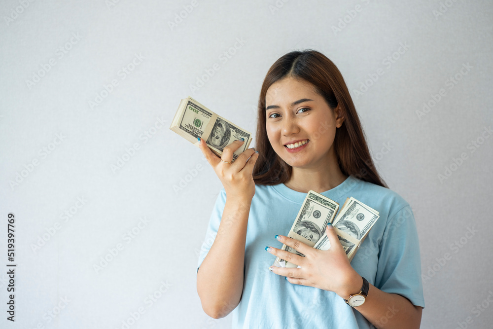 Excited Asian woman with rich and rich holding dollar bills income and salary concept Excited Asian woman with rich and rich holding dollar bills income and salary concept