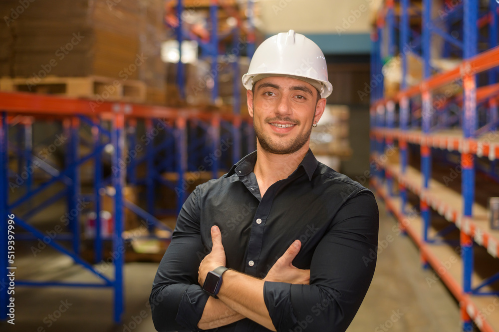 Portrait of young caucasian male worker wearing helmet in modern warehouse storage of retail shop Portrait of young caucasian male worker wearing helmet in modern warehouse storage of retail shop
