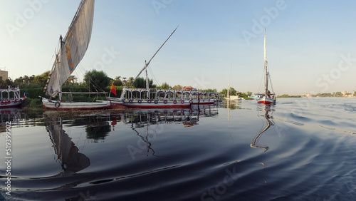 Sailing tourist and fishing boats are moored for the night on the river. Scenic view of the mirror surface of the water