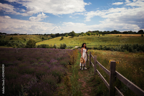 young beautiful elegant asian woman in white dress holding bouquet of lavender flower walking in bloom field outdoors leisure lifestyle