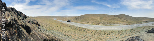 Panorama of open road. Wide view of the steppe landscape of winding road between hills  rock. Blue sky. Beautiful nature landscape background banner