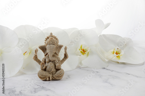 Happy Ganesh Chaturthi festival, Lord Ganesha statue with beautiful orchid flowers on white background, photo