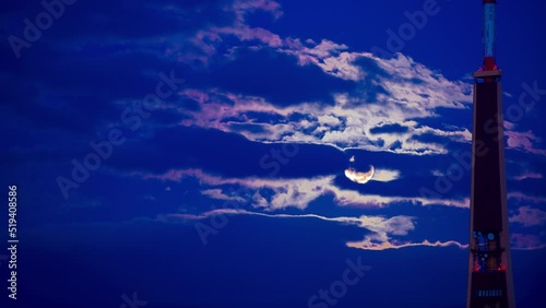 Full moon in Riga, Moonrise over the TV tower in the capital of Latvia. The moon in the blue sky and floating clouds. photo