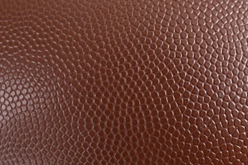 Texture of American football ball leather as background, closeup