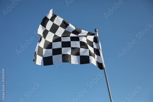 Checkered finish flag on light blue background © New Africa