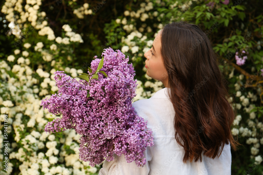 Woman with lilac flowers outdoors, back view Woman with lilac flowers outdoors, back view