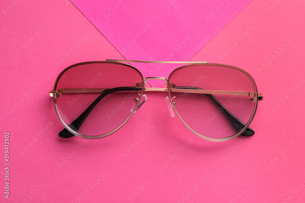 New stylish sunglasses on pink background, top view New stylish sunglasses on pink background, top view
