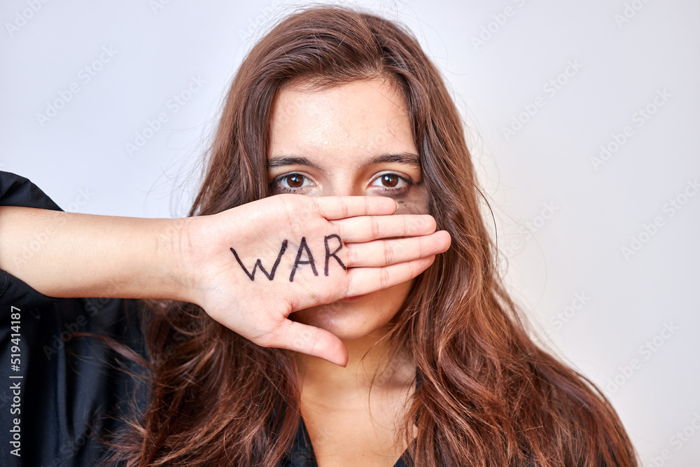 Φωτογραφία A beautiful girl in a black shirt covers her mouth with her hand with the inscri