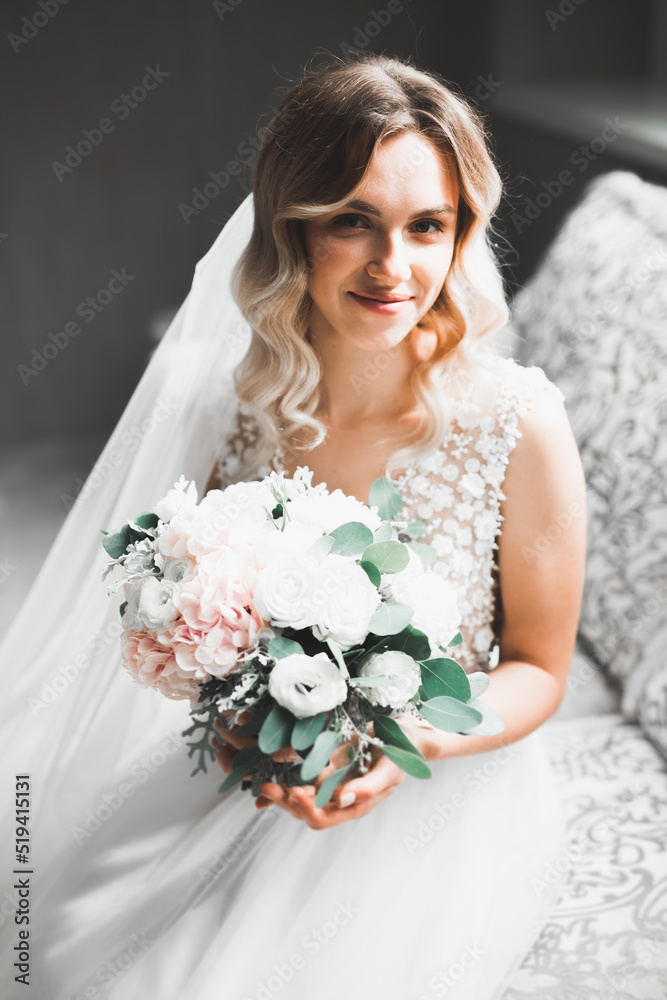 Naklejka premium Portrait of stunning bride with long hair posing with great bouquet