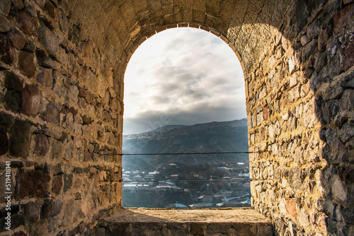 Fotografie, Tablou Stone arched window of Rabati Castle, Akhaltsikhe, Georgia, overlooking the town and mountains