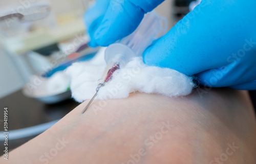 Fototapeta Naklejka Na Ścianę i Meble -  Close up nurse pricking needle syringe in the arm patient drawing blood sample for blood test