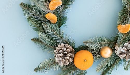 Christmas tree and tangerine on blue background