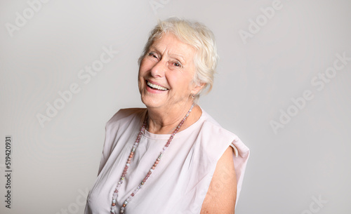 smiling retired senior woman looking at camera isolated on white background