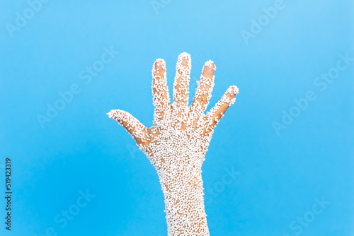 A hand with a palm with stuck balls of polystyrene. The concept of stopping environmental pollution. photo