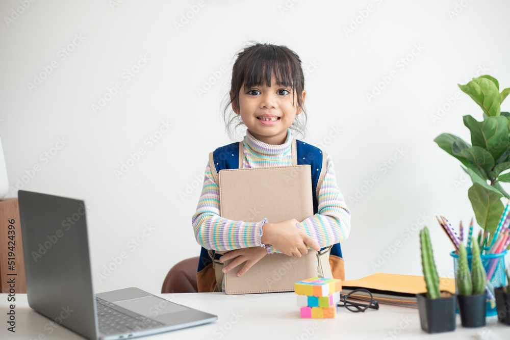 Asian student girl wearing school backpack and holding exercise book. Portrait of happy Asian young girl.Back to school Asian student girl wearing school backpack and holding exercise book. Portrait of happy Asian young girl.Back to school