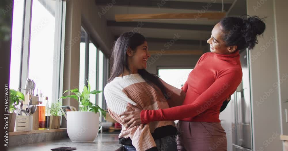 Video of happy biracial female friends embracing