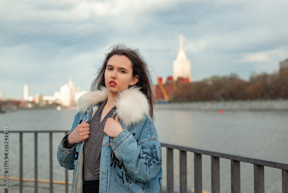 Fototapeta premium young woman walking along the embankment of the city
