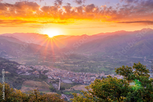 graet highland landscape with scenic view from mountain to below to a walley with majectic mountains and scenic cloudy sunset on background photo