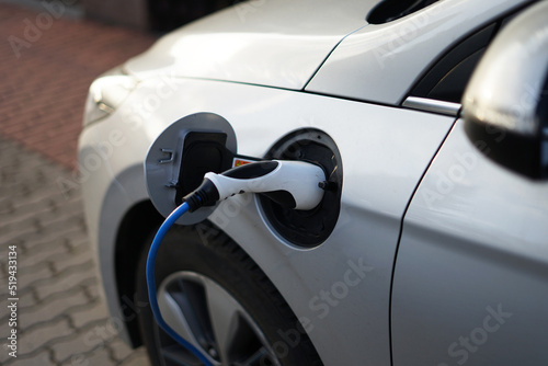 Modern EV electric car charging at home using green electric energy, future of transport concept