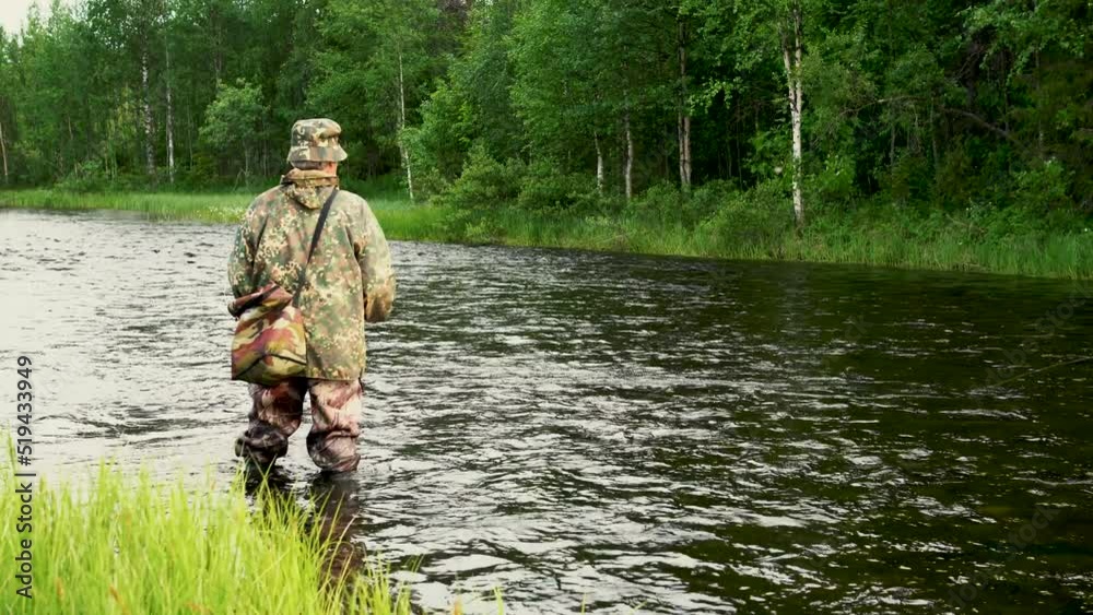 Summer day, a man is fishing with fly fishing in a mountain river Summer day, a man is fishing with fly fishing in a mountain river