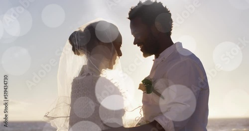 Animation of dots over happy african american newly married couple on beach