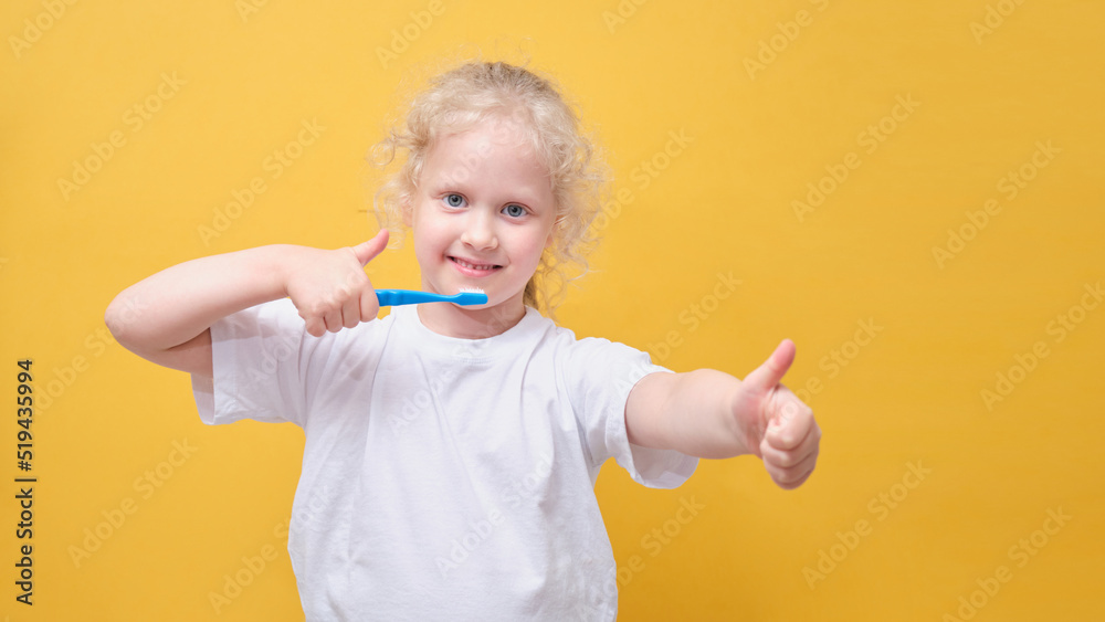 little toddler girl 6 years old holding toothbrush in hand, brushing tooth, yellow background little toddler girl 6 years old holding toothbrush in hand, brushing tooth, yellow background