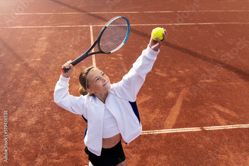 Close-up overhead view of a Preteen Girl playing serving at a tennis match