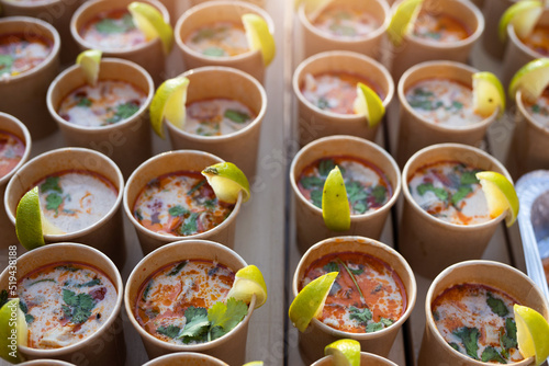 ready-made tom yum soup in paper cups with lemon