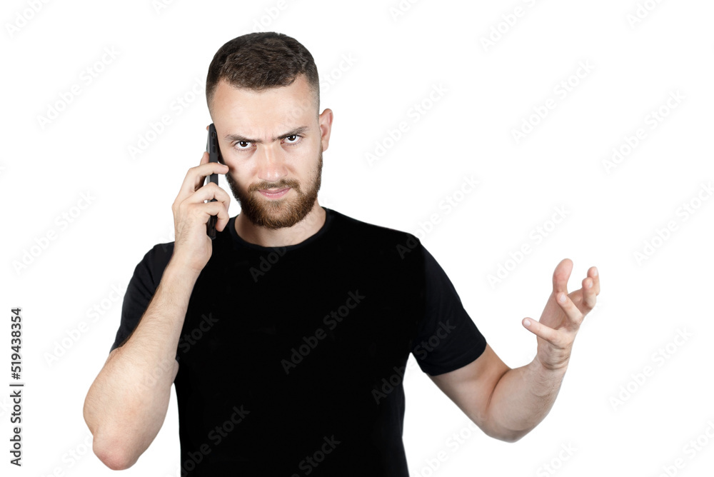A young man on a white background in a black t-shirt is talking on the phone and waving his hands, he is angry, dissatisfied with the conversation, the result of his order, isolated A young man on a white background in a black t-shirt is talking on the phone and waving his hands, he is angry, dissatisfied with the conversation, the result of his order, isolated