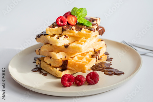 delicious belgian waffles for breakfast with strawberries and raspberries and chocolate