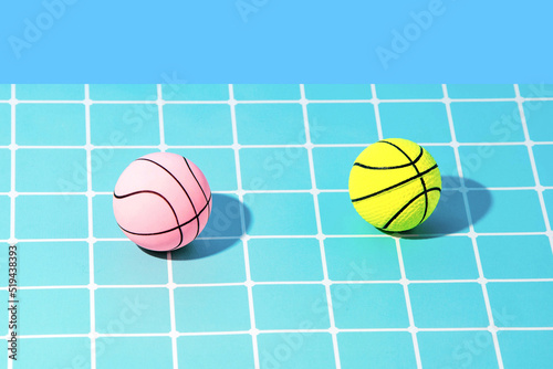 Summer trendy, creative idea in the pool with a pink swimming rubber and a ball on a pastel blue background. 80s or 90s retro aesthetic fun idea. Minimal composition.