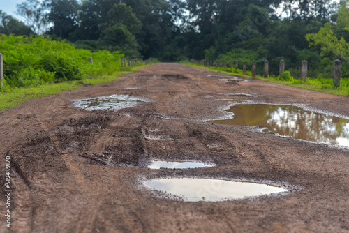 Rural damaged road with muds and holes