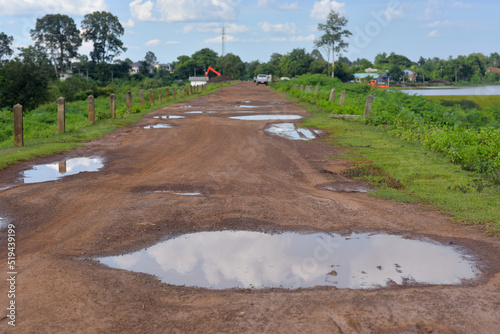 Rural damaged road with muds and holes