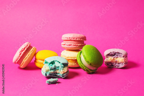 Bright colorful various flavor macarons sweet cookies on high-colored pink background photo