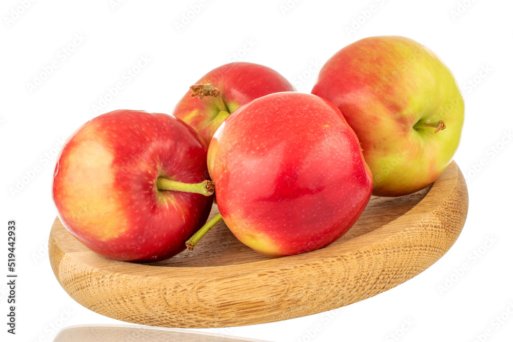 Several ripe sweet red apples with a wooden saucer, close-up isolated on a white background. Several ripe sweet red apples with a wooden saucer, close-up isolated on a white background.