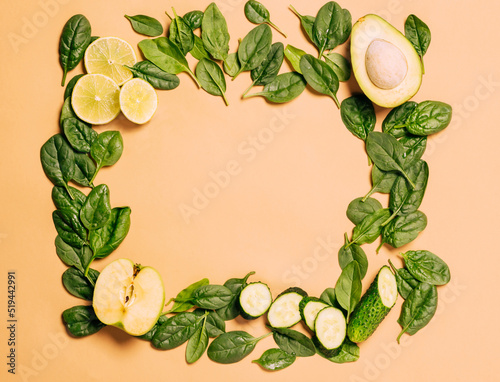 Fototapeta Naklejka Na Ścianę i Meble -  Green fresh fruits and vegetables, spinach, apple, lime, avocado, cucumber light brown background