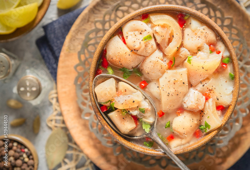 Arabic cuisine; Egyptian traditional boneless trotters soup. served with fresh lemon and black pepper. Top view with close up. photo