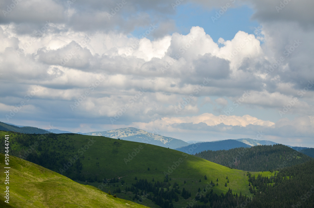 Beautiful panoramic view of highland to green mountain hills with forest landscape with cloudy blue sky. Carpathian Mountains, Ukraine