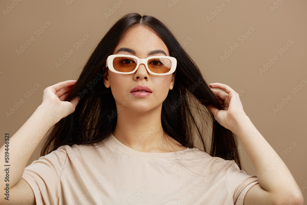 young woman in a beige T-shirt with glasses posing clothing fashion studio model young woman in a beige T-shirt with glasses posing clothing fashion studio model