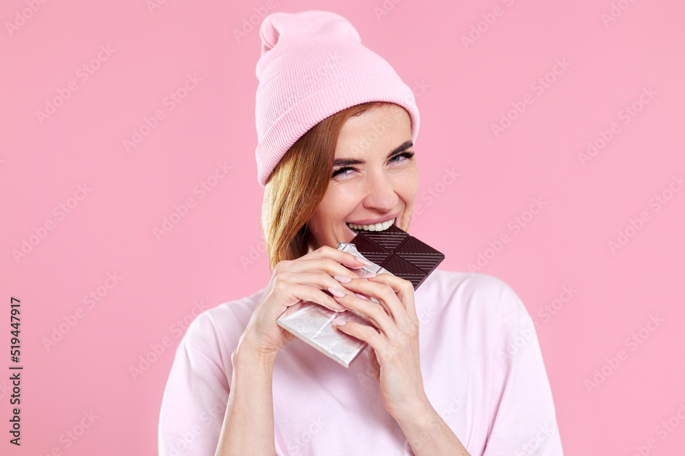 young happy woman in casual t-shirt biting sweet chocolate bar young happy woman in casual t-shirt biting sweet chocolate bar