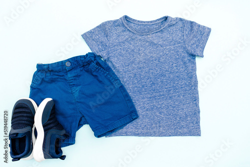 Summer babies blue clothes and accessories with t shirt, shorts,sneakers. Modern fashion kids casual outfit.Set of children's clothing for spring. Flat lay, top view,overhead,mockup