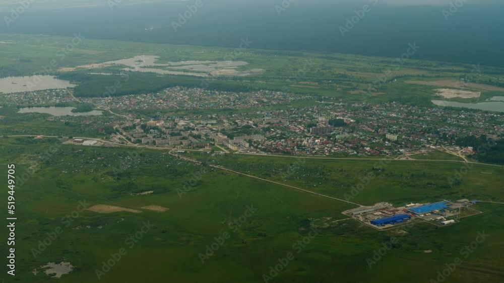 Panorama of residential area and nature from airplane window. Fly high above the city. Tourism and travel concept