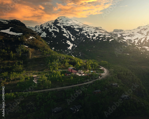 Sunset above a Norwegian hut in front of a snowy mountain