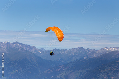 Man with parachute above mountain peaks in Austria photo