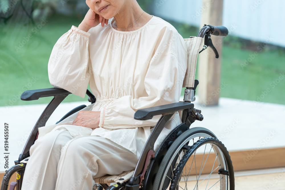 Obraz premium 車椅子に乗った落ち込むシニア女性(介護・怪我)