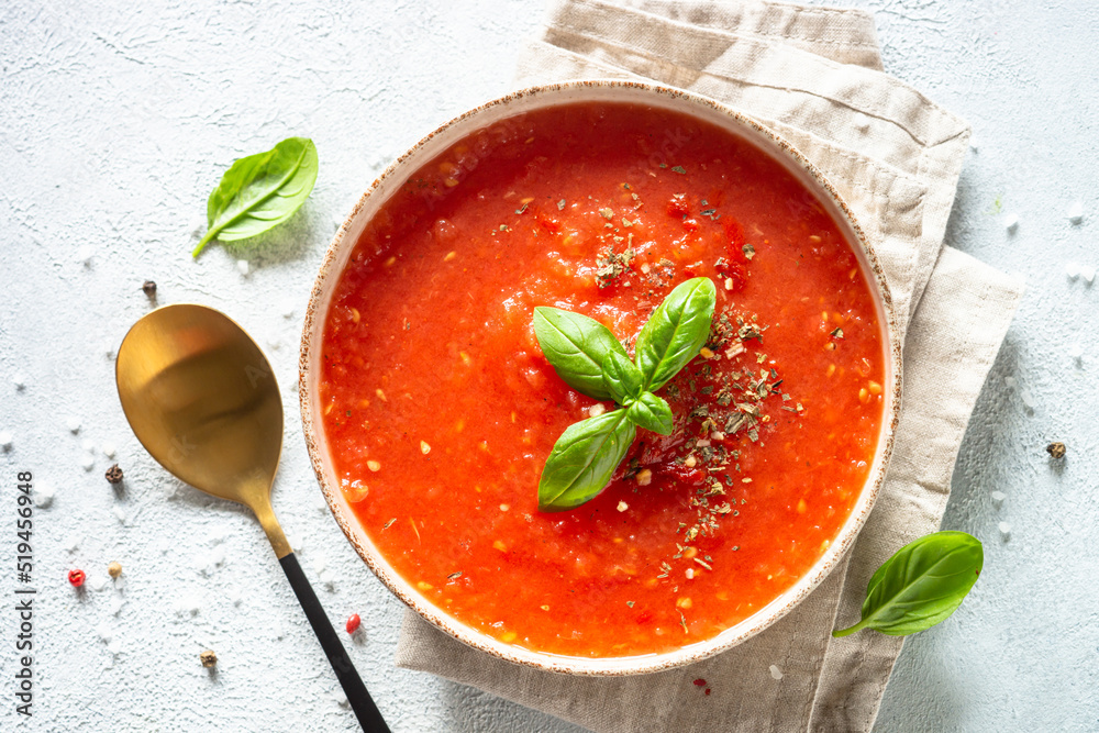 Tomato soup with spices and basil. Cold summer soup. Top view on white background. - obrazy, fototapety, plakaty 