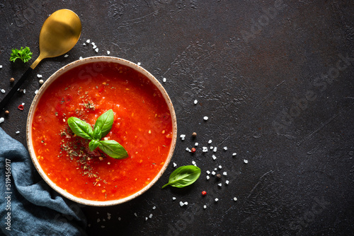 Tomato soup on black background. Traditional vegan dish. Top view with copy space.